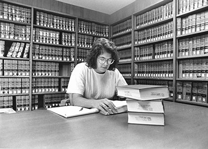 An individual sitting at a table in the UCLA Law Library